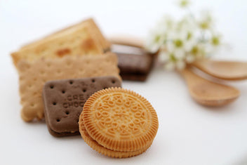 Assorted Khong Guan biscuits arranged in the brand's classic tin